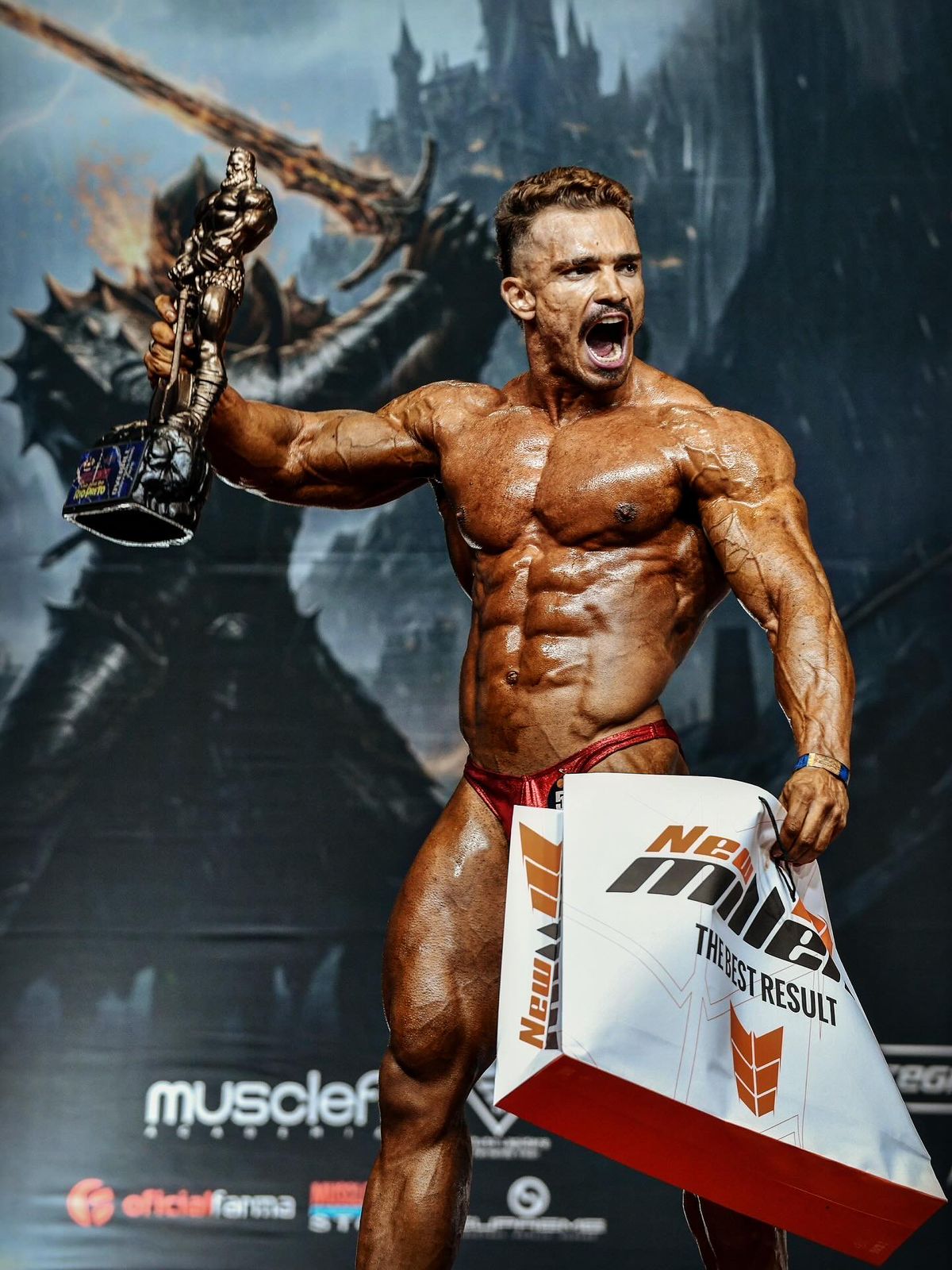 Leonardo Pereira comemorando título de campeão overall de fisiculturismo, erguendo o troféu
