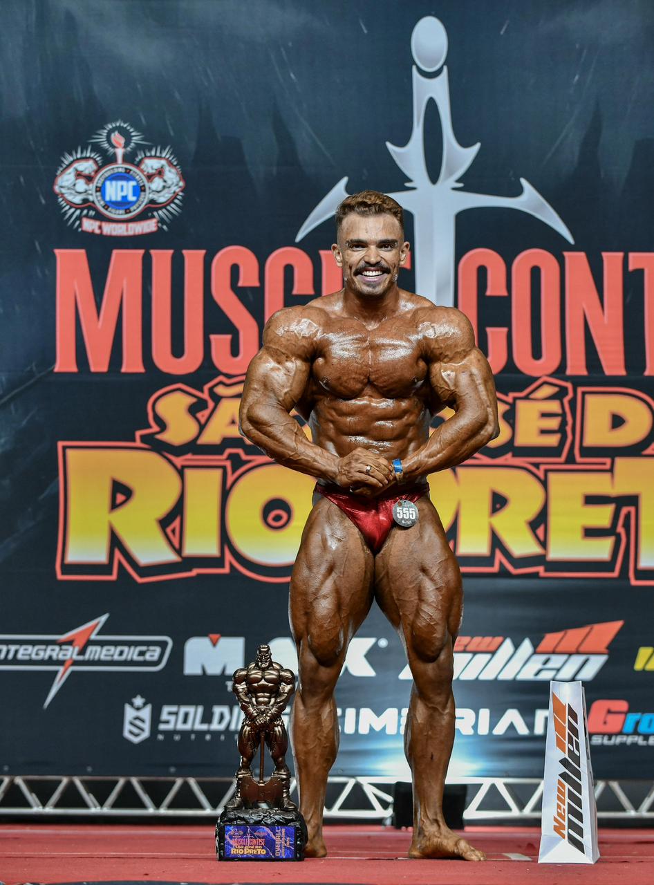Leonardo Pereira posando com troféu de campeão overall no Muscle Contest